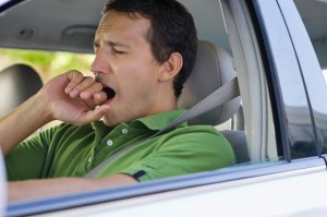 Mid adult man yawning while driving a car